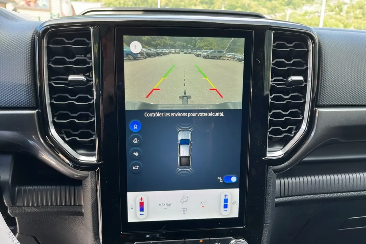 Écran central du Ford Ranger 2025 montrant la caméra de recul et les capteurs d'aide au stationnement.