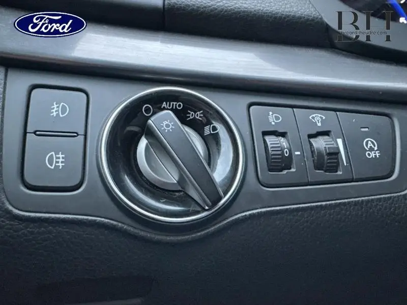 Gros plan sur les commandes d'éclairage et d'assistance au freinage d'urgence dans un intérieur noir de Hyundai i40 SW Sleek Silver.