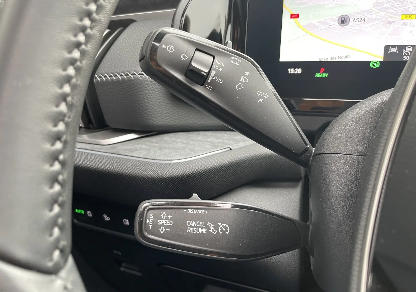 Gros plan sur les commandes au volant du Skoda Kodiaq noir métal 2024, avec affichage GPS et réglages de vitesse visibles.