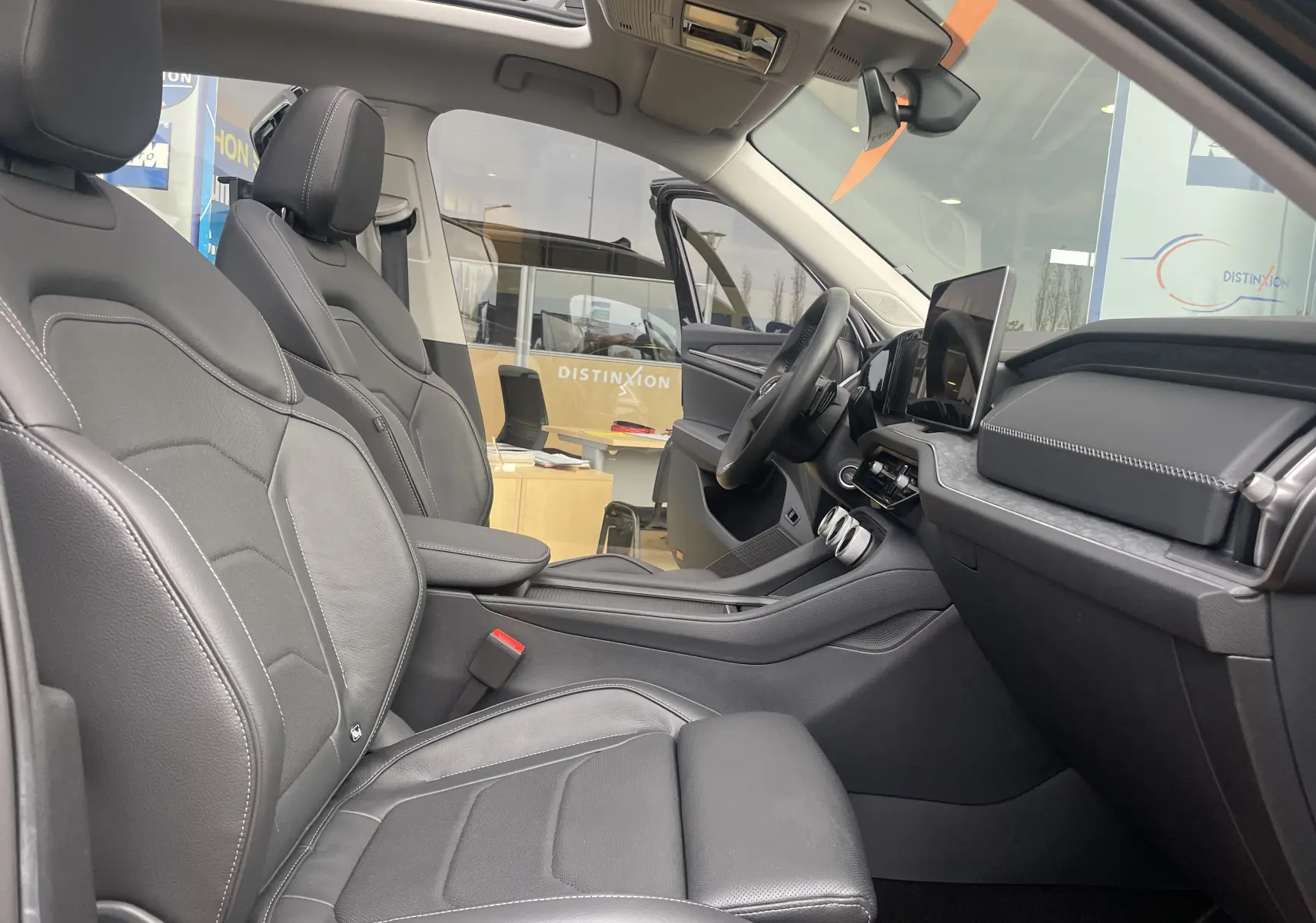 Intérieur noir cuir du Skoda Kodiaq 2024, vue côté droit sur sièges avant et tableau de bord moderne.