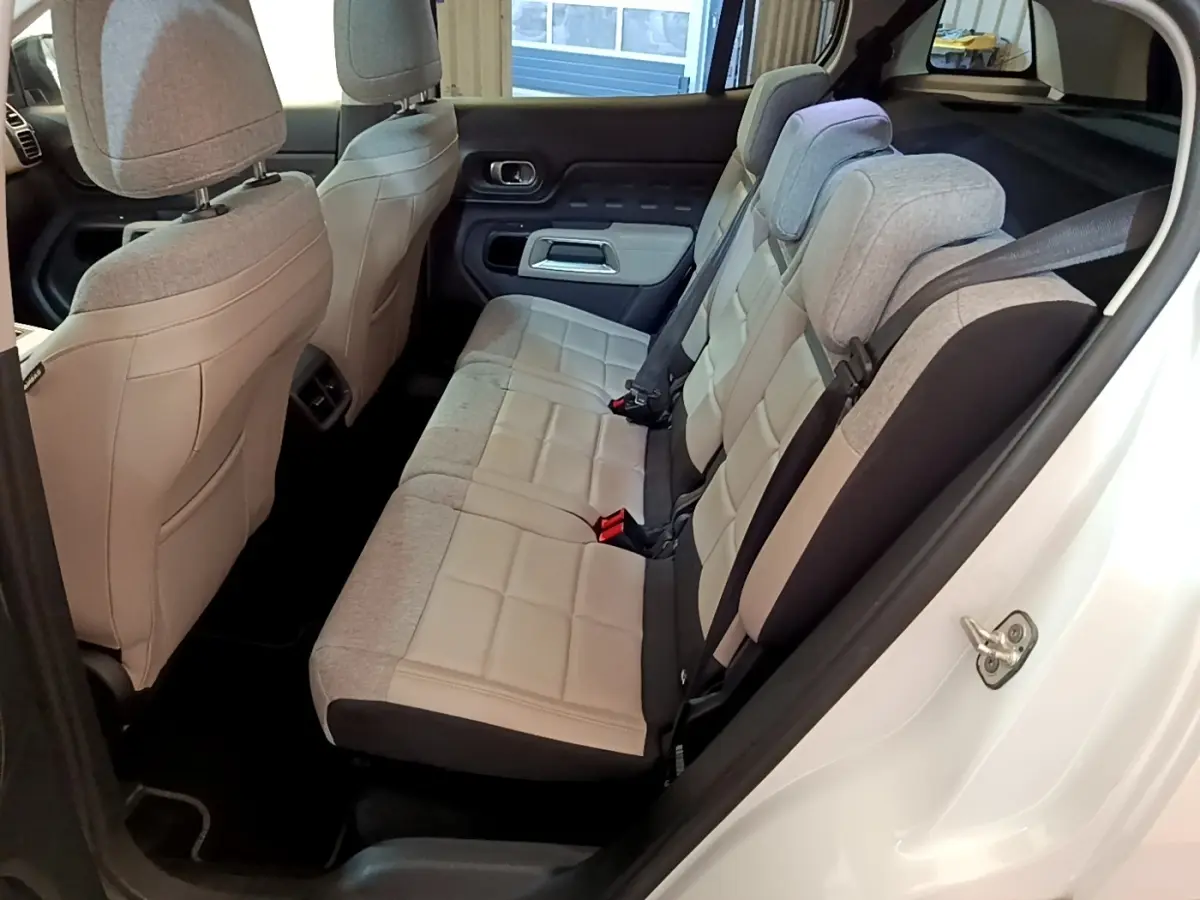Vue intérieure côté droit des sièges arrière gris clair du Citroën C5 Aircross Hybrid blanc, avec ceinture de sécurité visible.