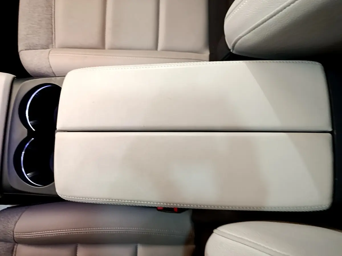 Gros plan sur l'accoudoir central beige et les porte-gobelets éclairés du Citroën C5 Aircross Hybrid 225 ë-EAT8 Shine Pack.