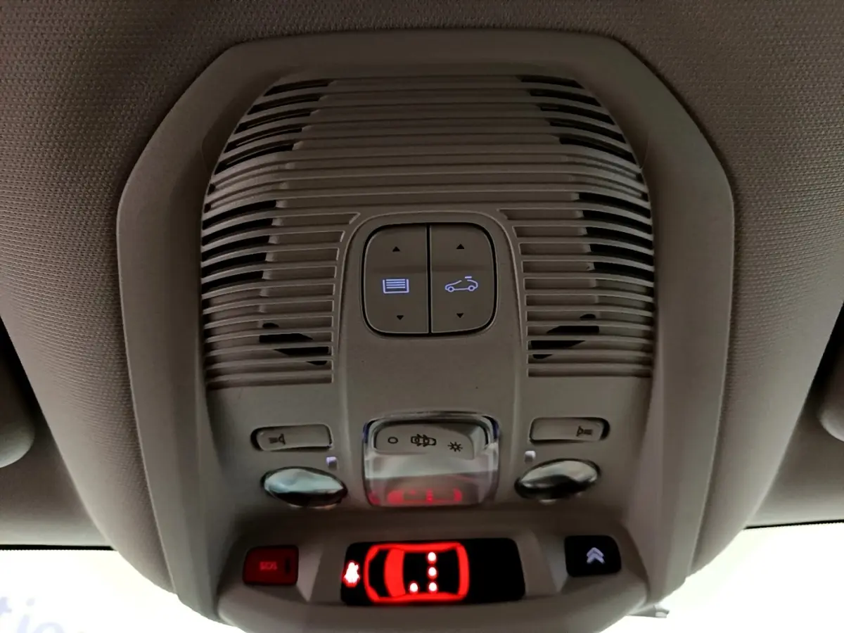 Vue intérieure du plafonnier avec commandes d'ouverture de toit et bouton SOS du Citroën C5 Aircross blanc hybride 2021.
