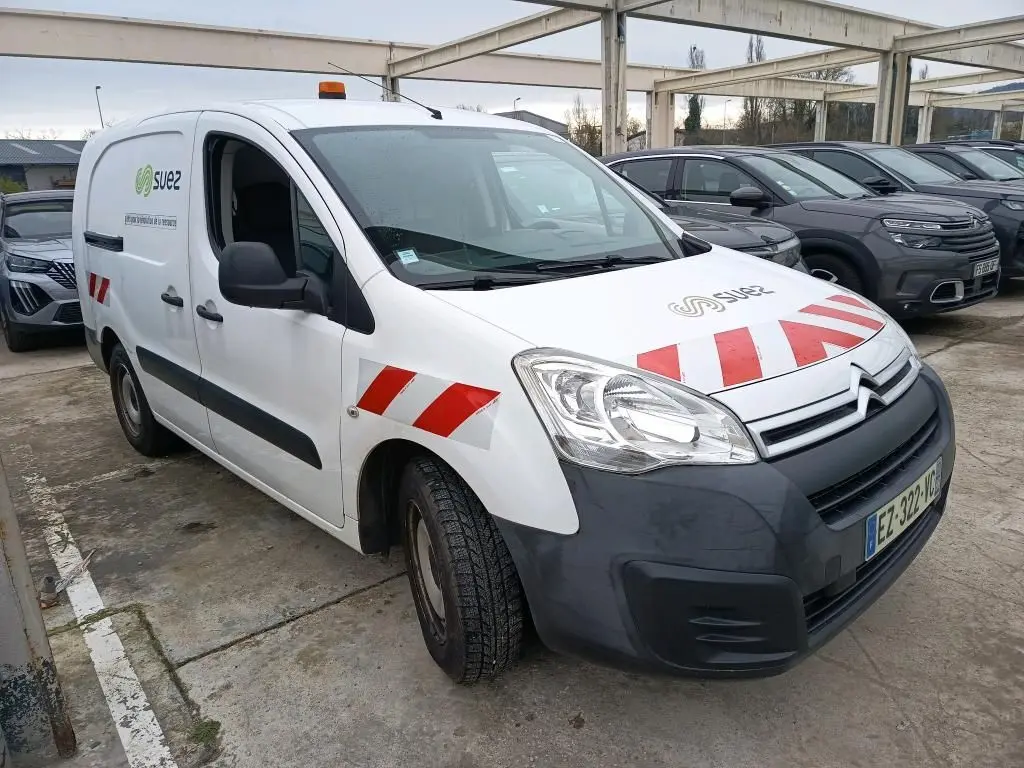 Vue 3/4 avant gauche d'un Citroën Berlingo blanc avec marquages rouges et logo Suez, équipé d'un gyrophare orange.