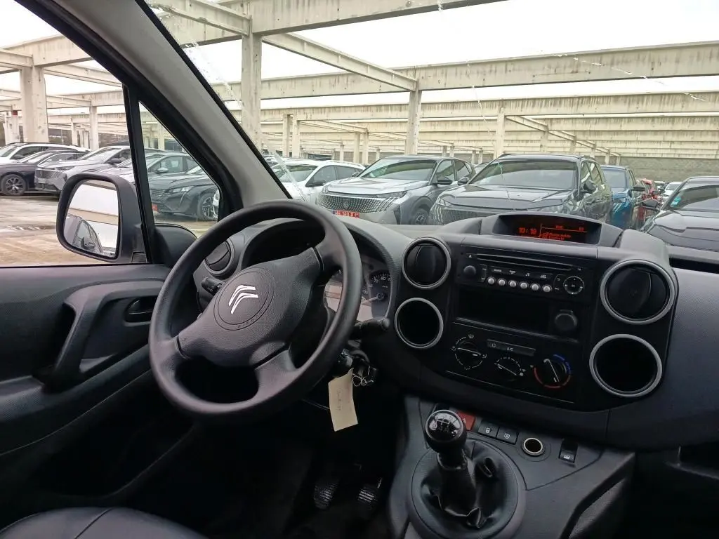 Vue intérieure côté conducteur du Citroën Berlingo blanc 2018, montrant le volant, tableau de bord et levier de vitesses manuel.