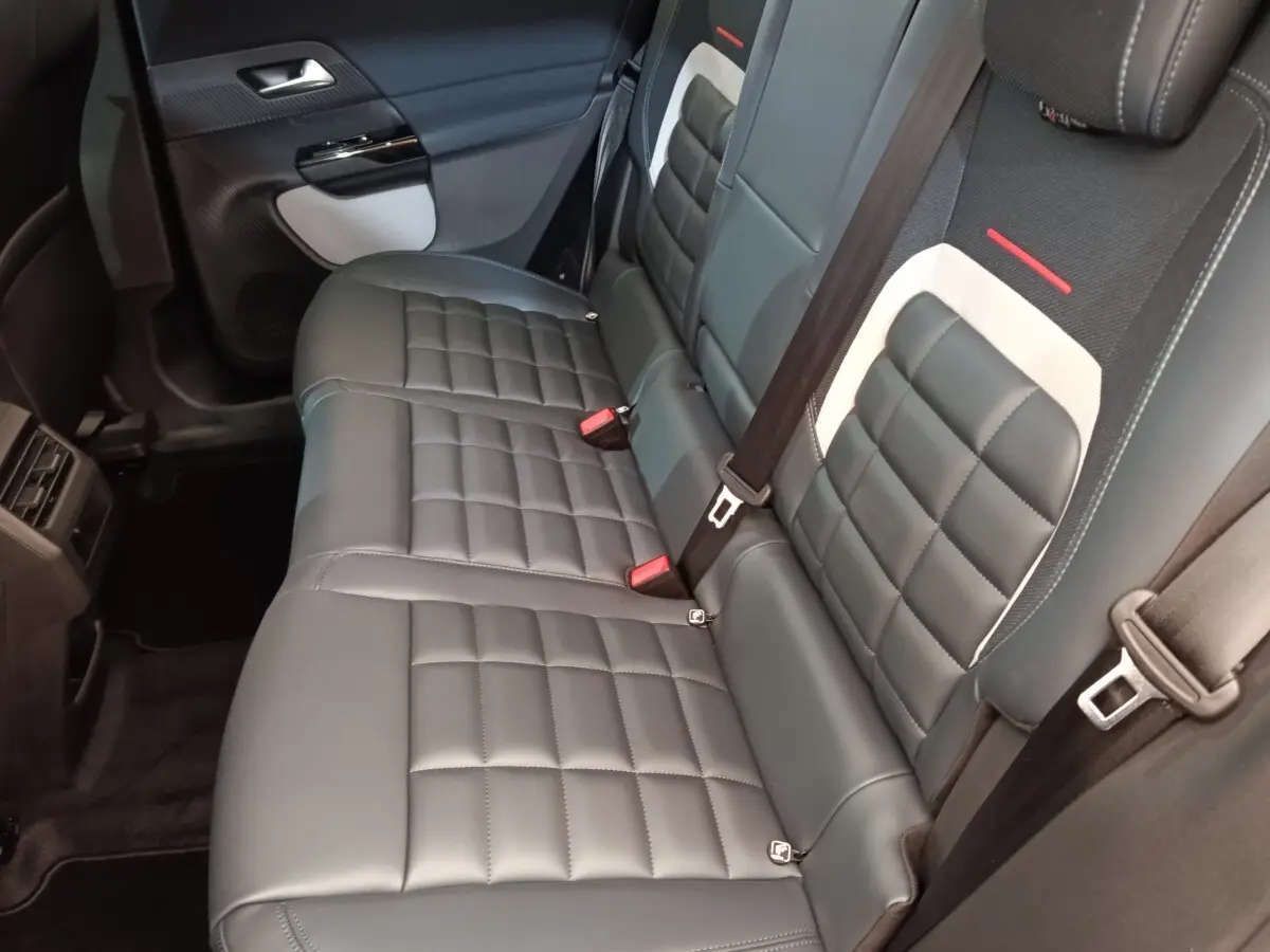 Vue intérieure côté droit des sièges arrière en cuir noir avec surpiqûres blanches du Citroën C5 hybride 2026.