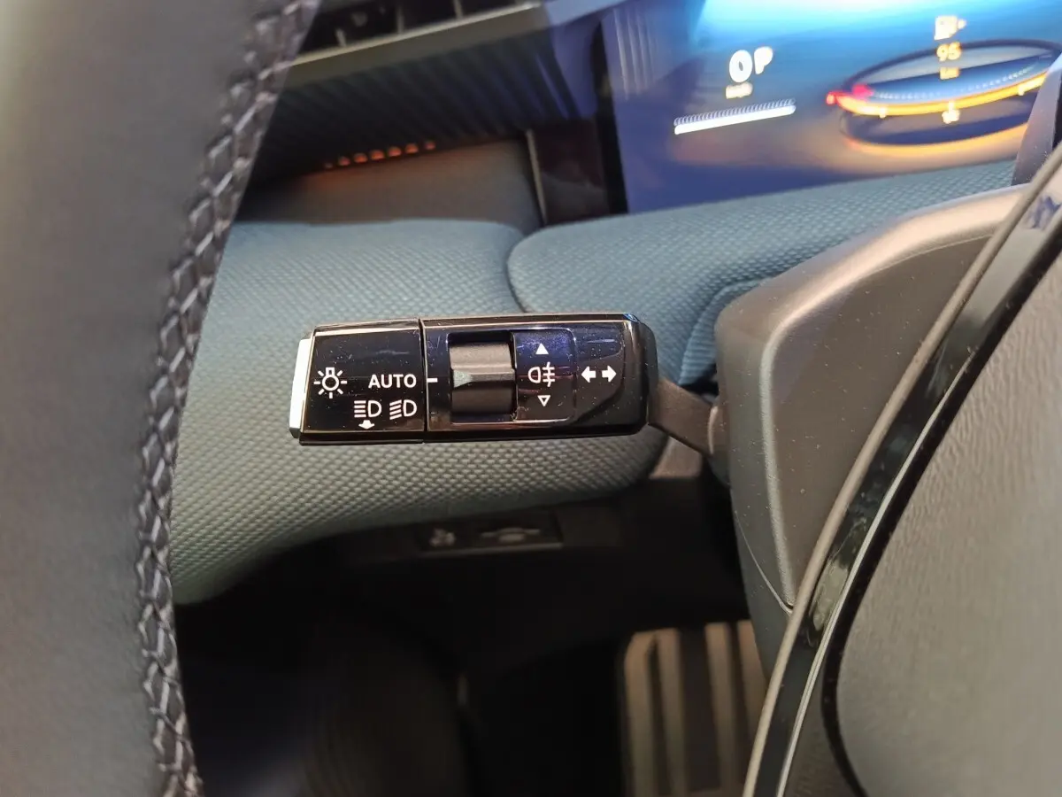 Gros plan sur la commande des feux et clignotants côté gauche du volant dans l’habitacle du Citroën C5 Hybride vert.