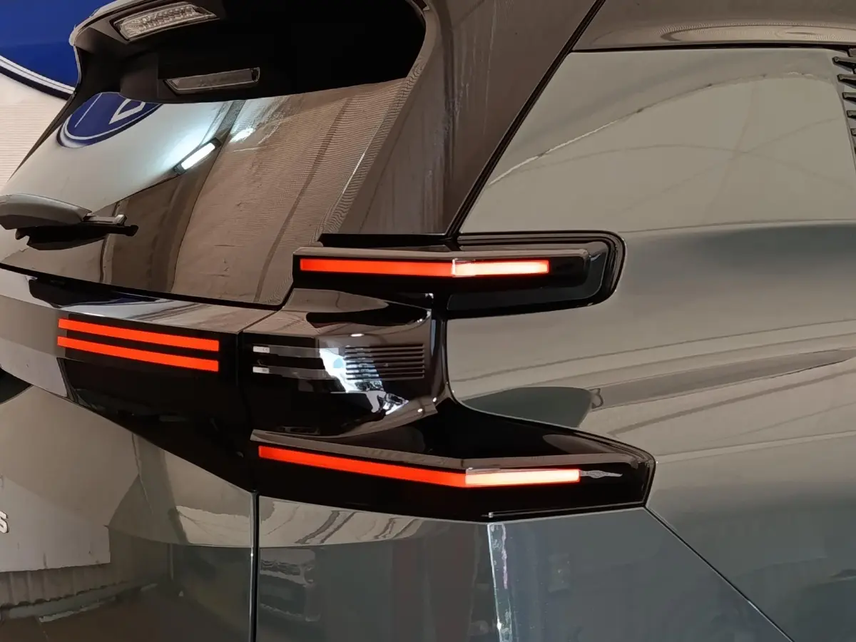 Gros plan sur l’arrière droit vert du Citroën C5 Hybride 2026 avec feux arrière LED distinctifs allumés.