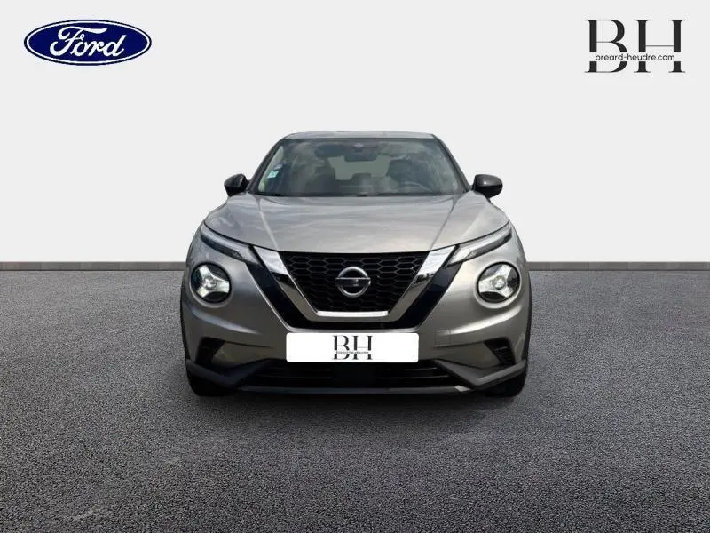 Vue frontale du Nissan Juke 2023 gris perle métallisé avec calandre noire distinctive et phares ronds LED.