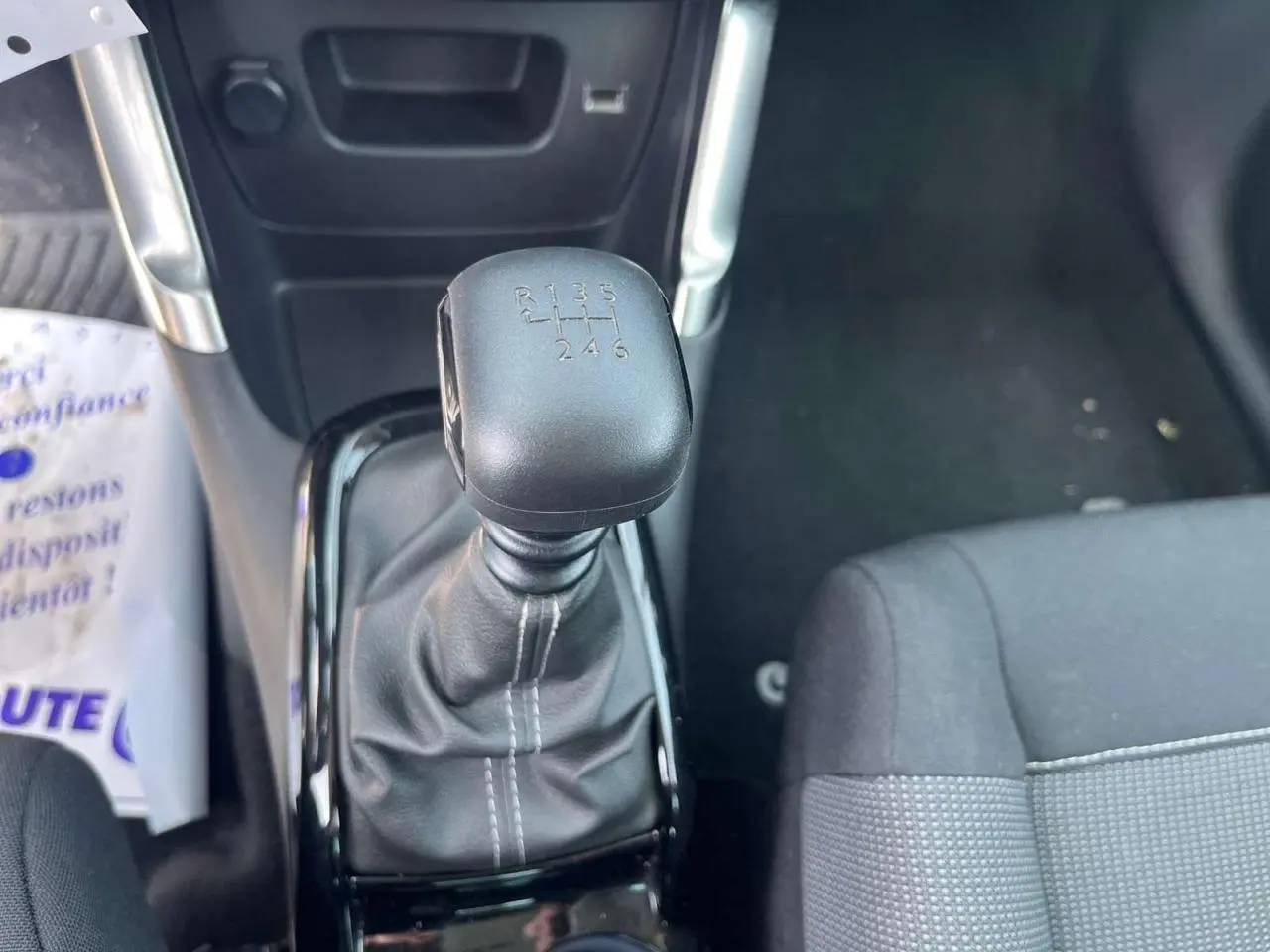 Le levier de vitesses manuel noir de la Citroën C3 Aircross 2023 vu de dessus avec siège tissu gris à droite.