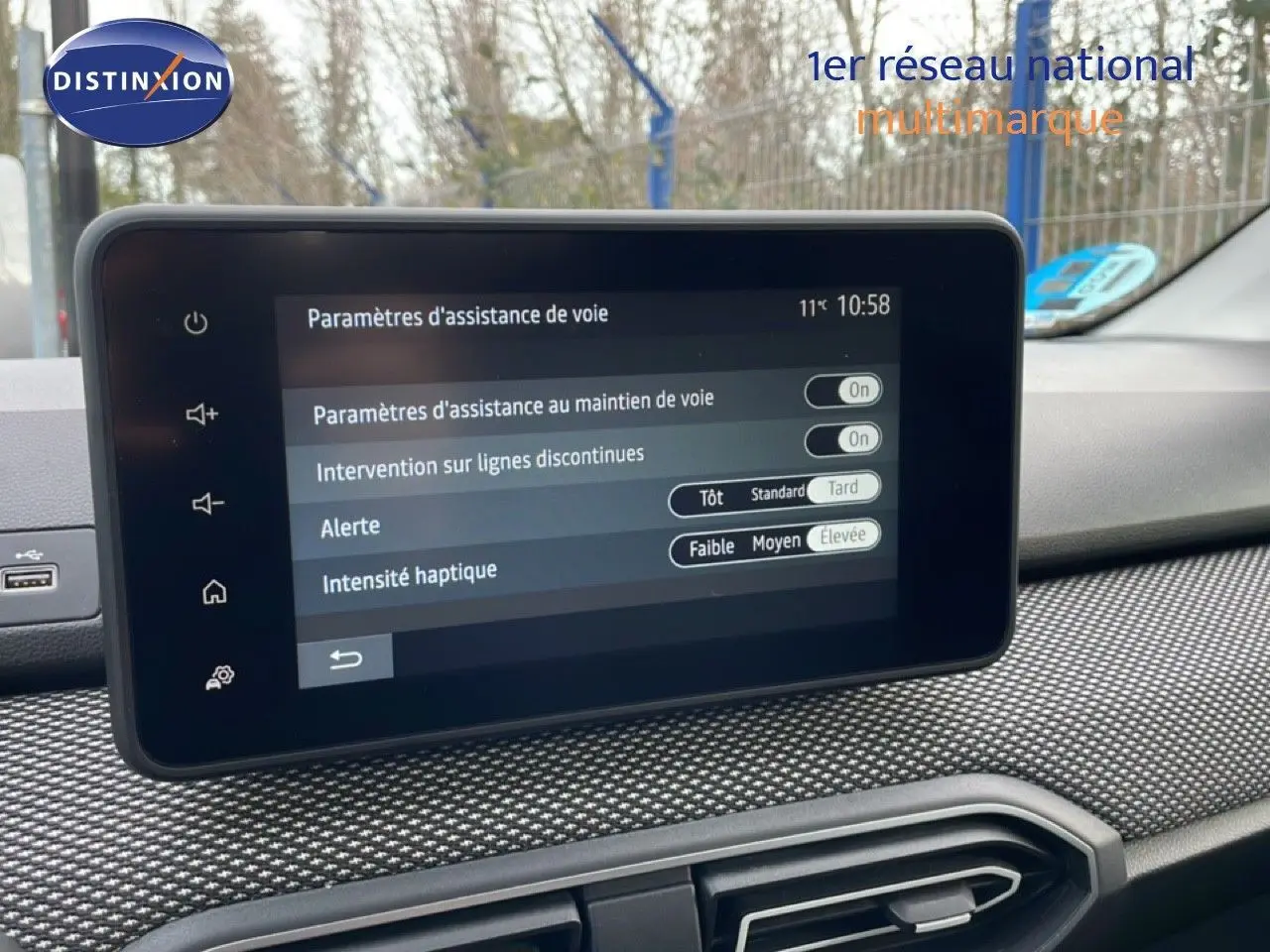 Vue intérieure centrée sur l'écran tactile du tableau de bord du Dacia Jogger gris schiste métal, affichant les réglages d'assistance de voie.