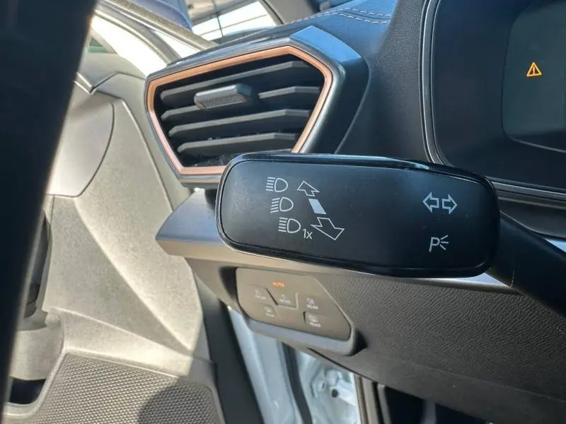 Gros plan sur la commande de clignotants à gauche du tableau de bord du CUPRA Formentor blanc Nevada métallisé 2025.