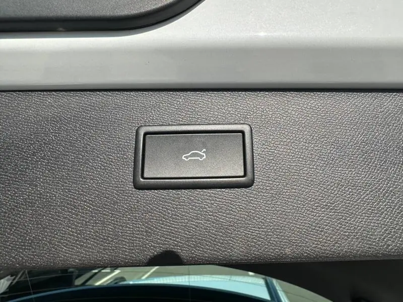 Bouton d'ouverture électrique du coffre sur la garniture intérieure du hayon d'un CUPRA Formentor blanc Nevada métallisé.