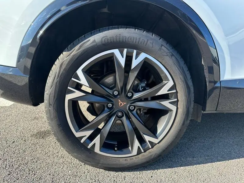 Gros plan sur la roue avant droite du CUPRA Formentor blanc Nevada métallisé, avec jante alliage noire et argentée distinctive.