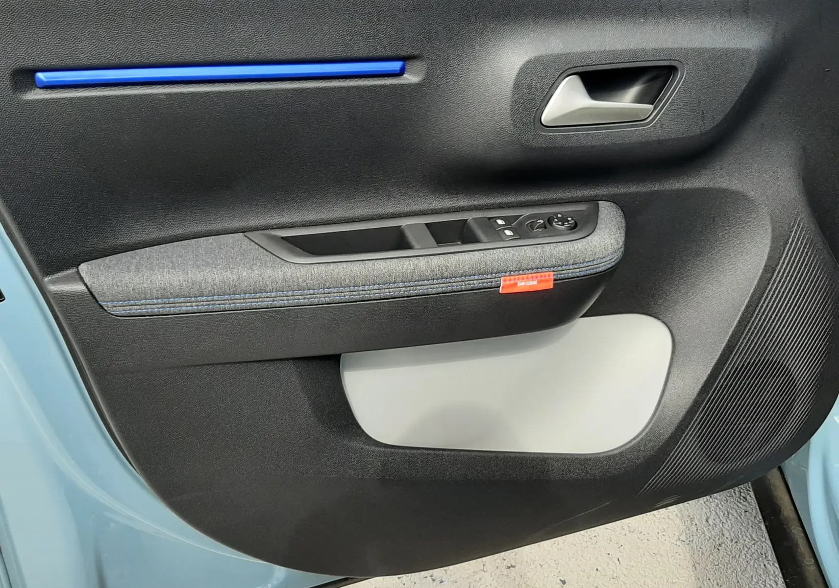 Vue rapprochée de la porte avant gauche de la Citroën C3 bleu Monte Carlo, avec insert bleu et tissu gris.