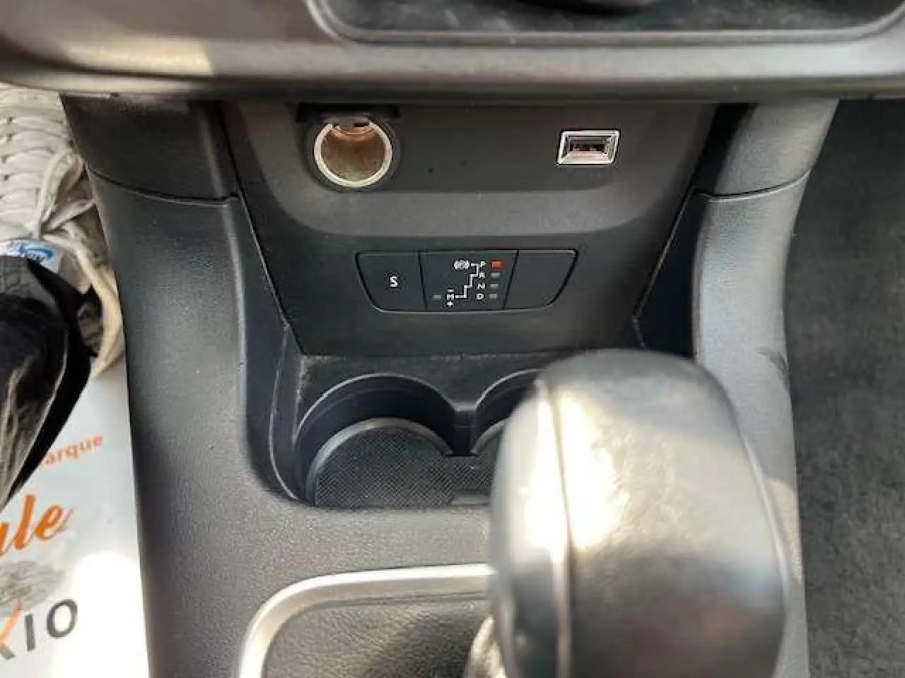 Gros plan sur la console centrale de la Citroën C3 2023, montrant le levier de boîte auto et prises USB et 12V.