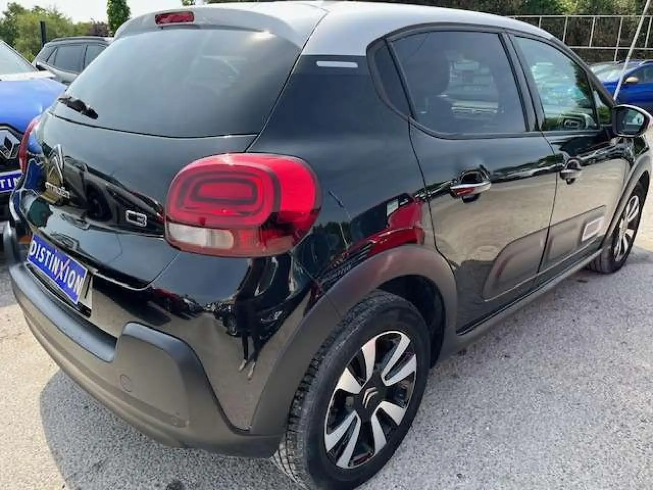Vue 3/4 arrière droite d'une Citroën C3 noire métal 2023 avec jantes alliage diamantées et vitres surteintées.