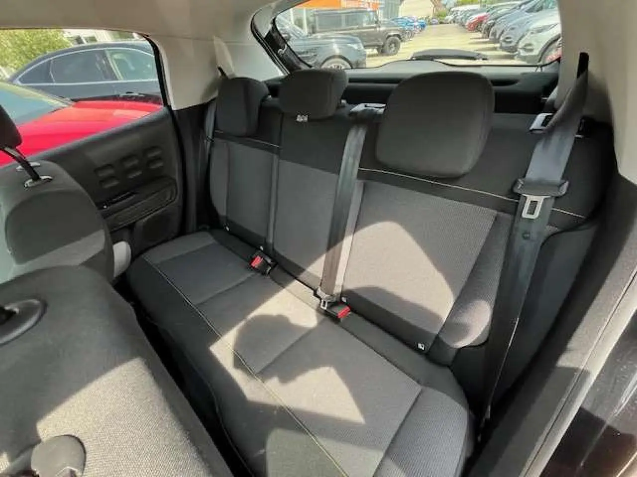 Vue intérieure de la banquette arrière noire de la Citroën C3 2023, avec ceintures et appuie-têtes visibles.