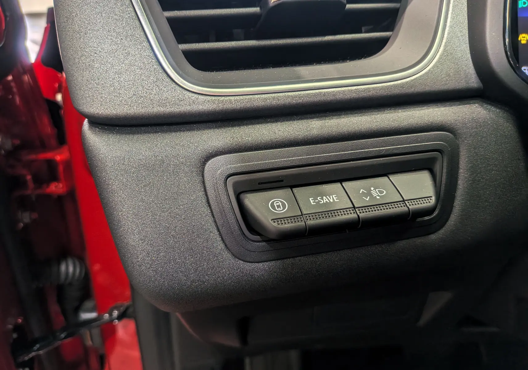 Boutons de commande E-SAVE et réglage des phares sur le tableau de bord noir du Renault Captur Rouge Flamme 2025.