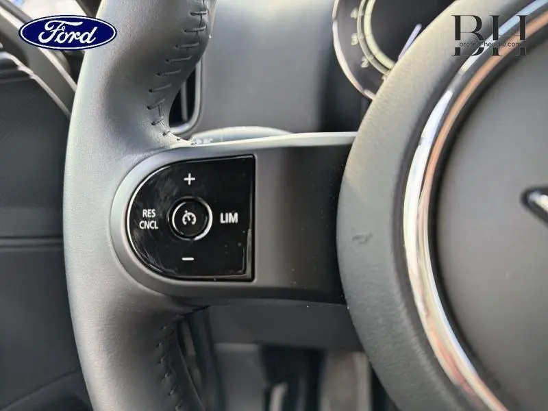 Gros plan sur les commandes de régulateur de vitesse au volant cuir du MINI COUNTRYMAN Melting Silver III, vue côté gauche.