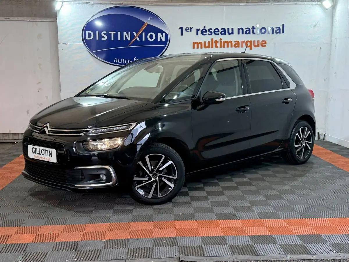 Citroën C4 Spacetourer noir vue 3/4 avant droit en intérieur avec jantes alliage et phares allumés.