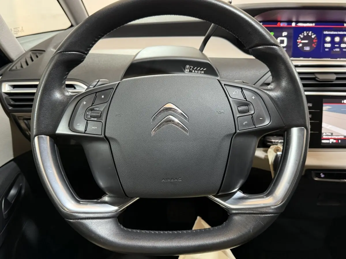 Vue rapprochée du volant cuir et alu noir du Citroën C4 Spacetourer 2020 avec tableau de bord numérique en arrière-plan.