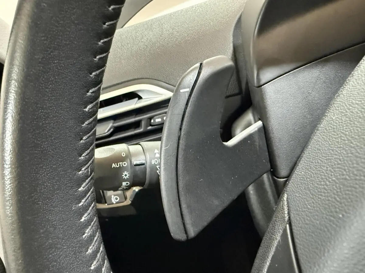 Gros plan sur la palette de changement de vitesse noire derrière le volant cuir du Citroën C4 Spacetourer 2020.