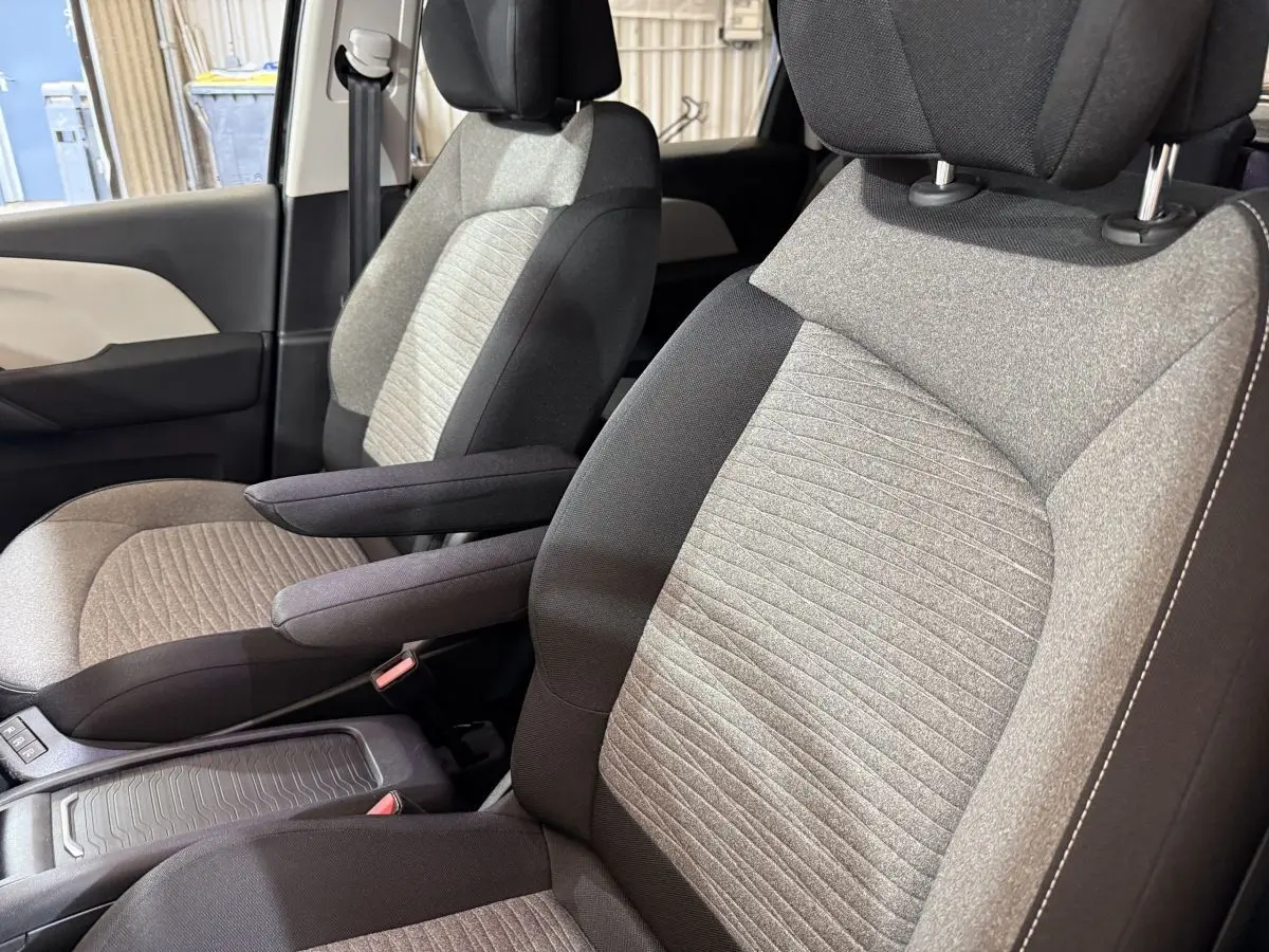 Gros plan sur les sièges avant bi-ton gris et noir du Citroën C4 Spacetourer 2020, avec accoudoirs et ceintures visibles.