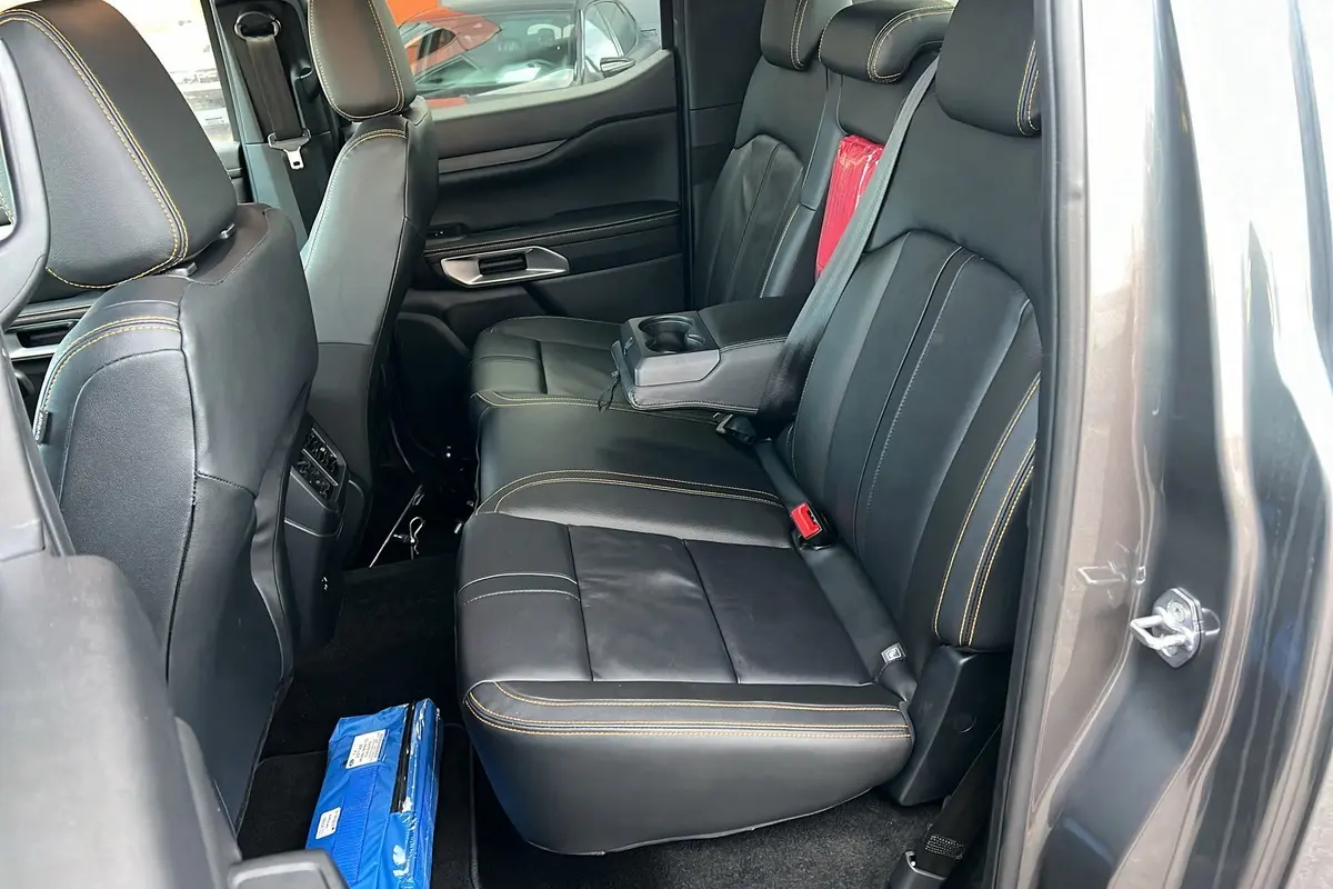 Vue intérieure côté droit des sièges arrière en cuir noir avec surpiqûres jaunes du Ford Ranger gris carbone 2025 Wildtrak Plus.