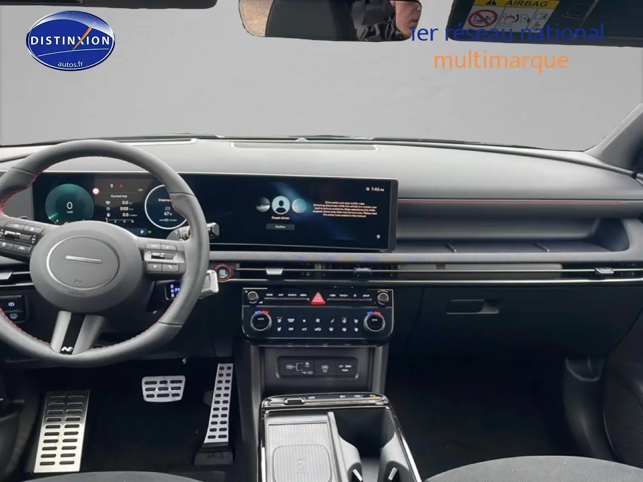 Vue intérieure frontale du tableau de bord du Hyundai Tucson gris, avec écran tactile large et volant sport N Line en cuir.