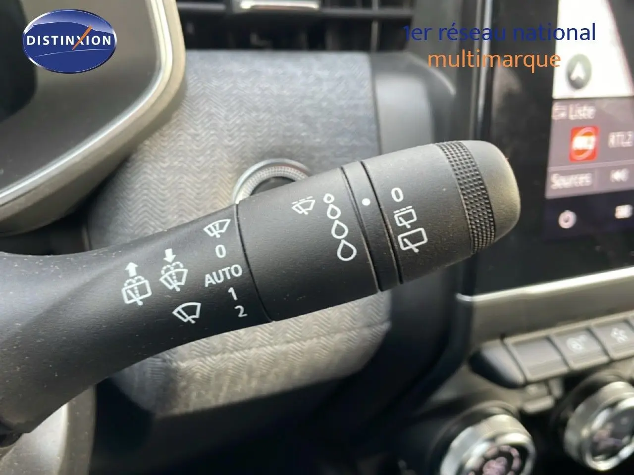 Gros plan sur la commande d’essuie-glace dans l’habitacle d’une Renault Clio rouge Désir Métal, version 2025.