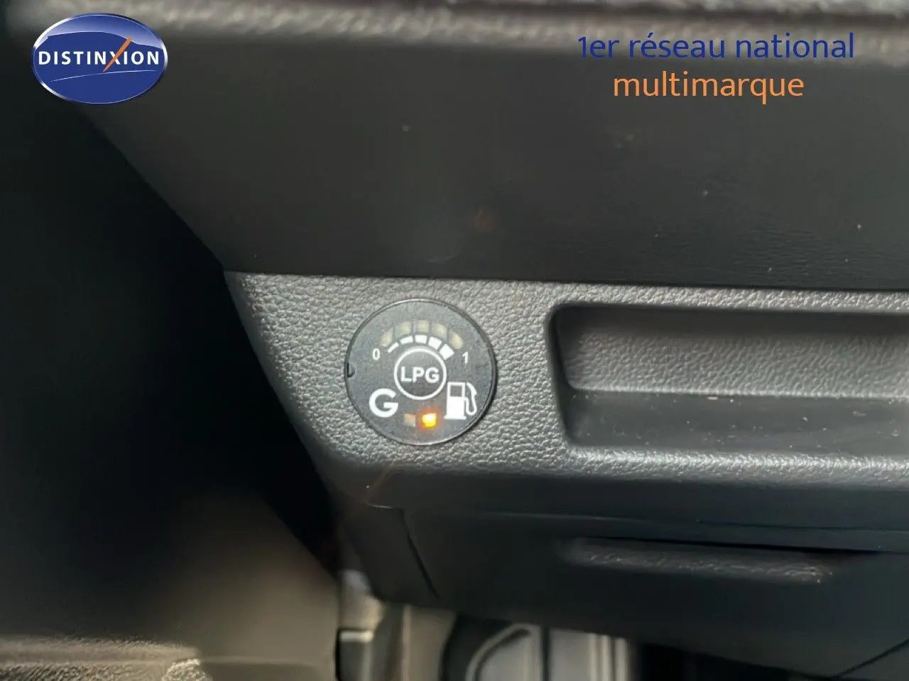 Gros plan sur le tableau de bord noir avec indicateur LPG allumé dans une Renault Clio rouge Désir Métal.