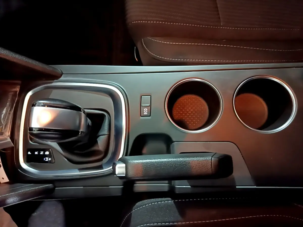 Vue plongeante sur la console centrale noire de la Renault Mégane Business Blue dCi 115 EDC avec levier de boîte auto et porte-gobelets.