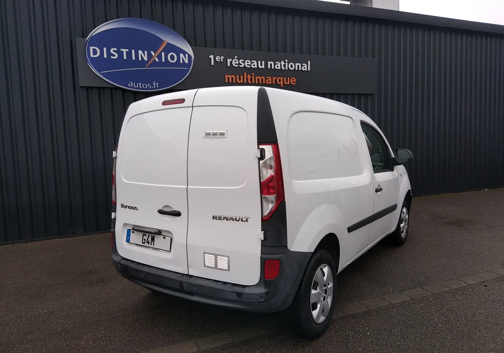 Renault Kangoo blanc en 3/4 arrière droit, utilitaire compact avec portes arrière battantes et feux verticaux.