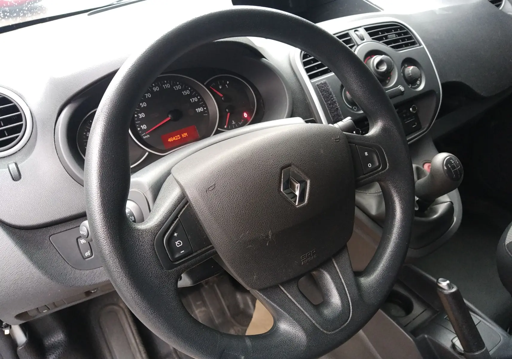 Intérieur du Renault Kangoo blanc 2019, vue rapprochée du volant multifonction et levier de vitesse manuel.