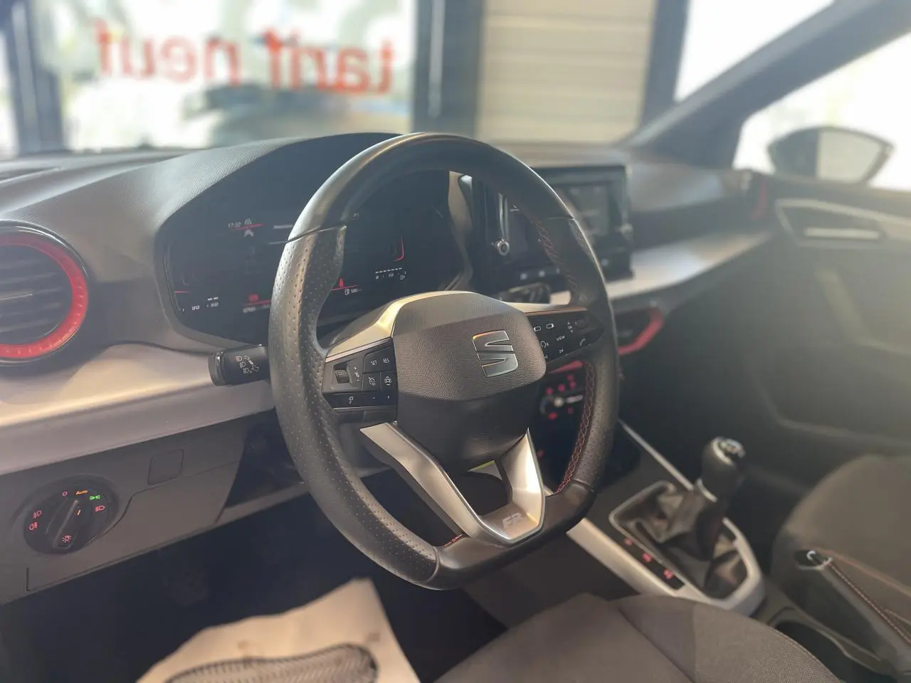 Intérieur du SEAT Arona 2024 vu côté conducteur, volant sport cuir noir avec logo FR et console centrale.