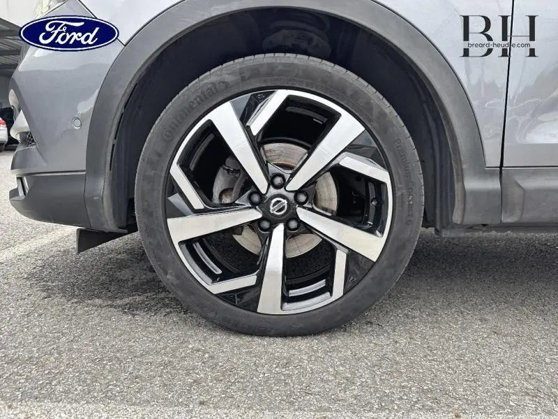 Gros plan sur la roue avant gauche du Nissan Qashqai gris Squale avec jante alliage noir et argent.