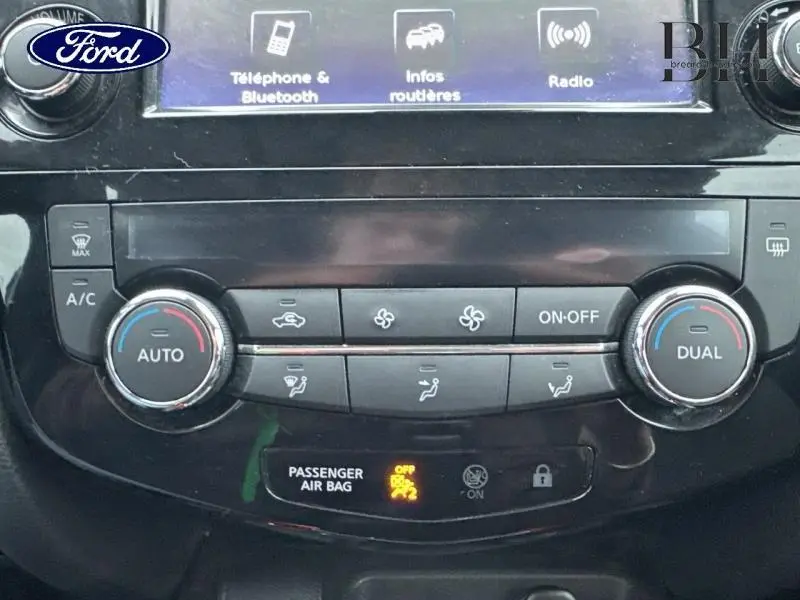 Tableau de bord noir du Nissan Qashqai 2018 avec commandes climatisation automatique bi-zone et écran tactile.