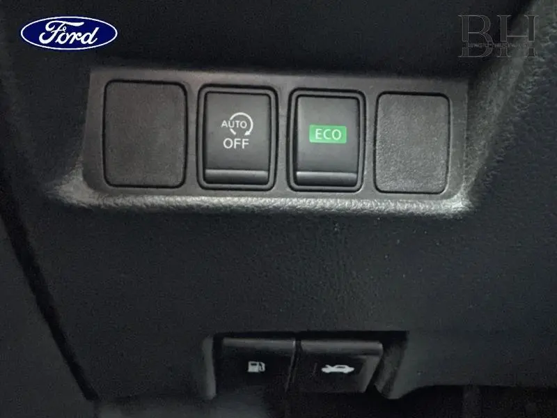 Panneau de commandes intérieures avec bouton ECO et AUTO OFF sur un tableau de bord noir, détail d'habitacle.