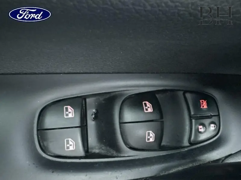 Gros plan sur les commandes de lève-vitres et verrouillage de porte noires à l'intérieur d'un Nissan Qashqai gris Squale.