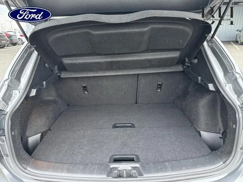 Coffre ouvert vu de l'arrière d'un Nissan Qashqai gris Squale, montrant un espace de chargement propre et spacieux.