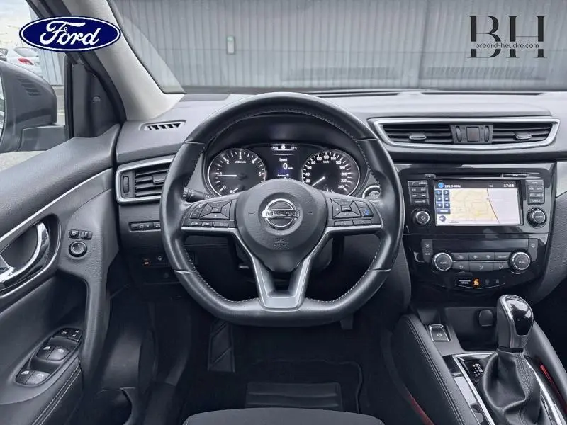 Vue intérieure centrée sur le volant cuir et tableau de bord du Nissan Qashqai 1.6 dCi gris avec écran tactile GPS.