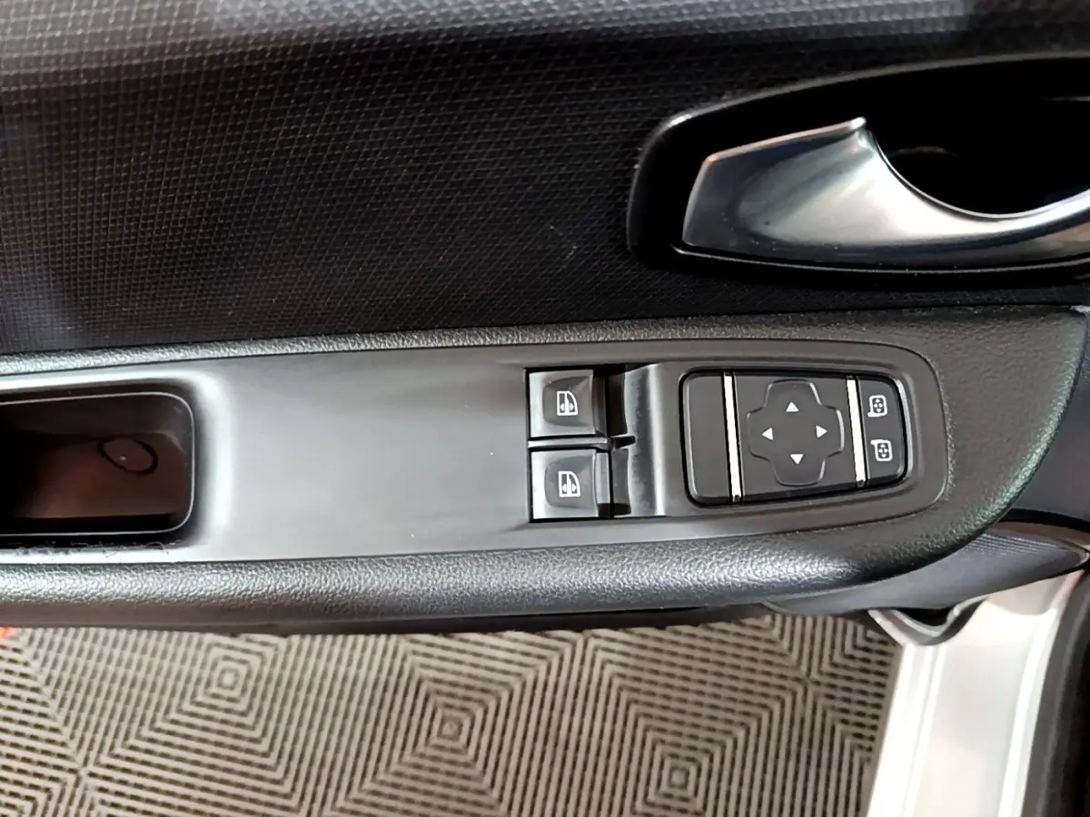 Gros plan sur la commande des vitres et rétroviseurs côté conducteur d'une Renault Clio Business gris clair 2018.