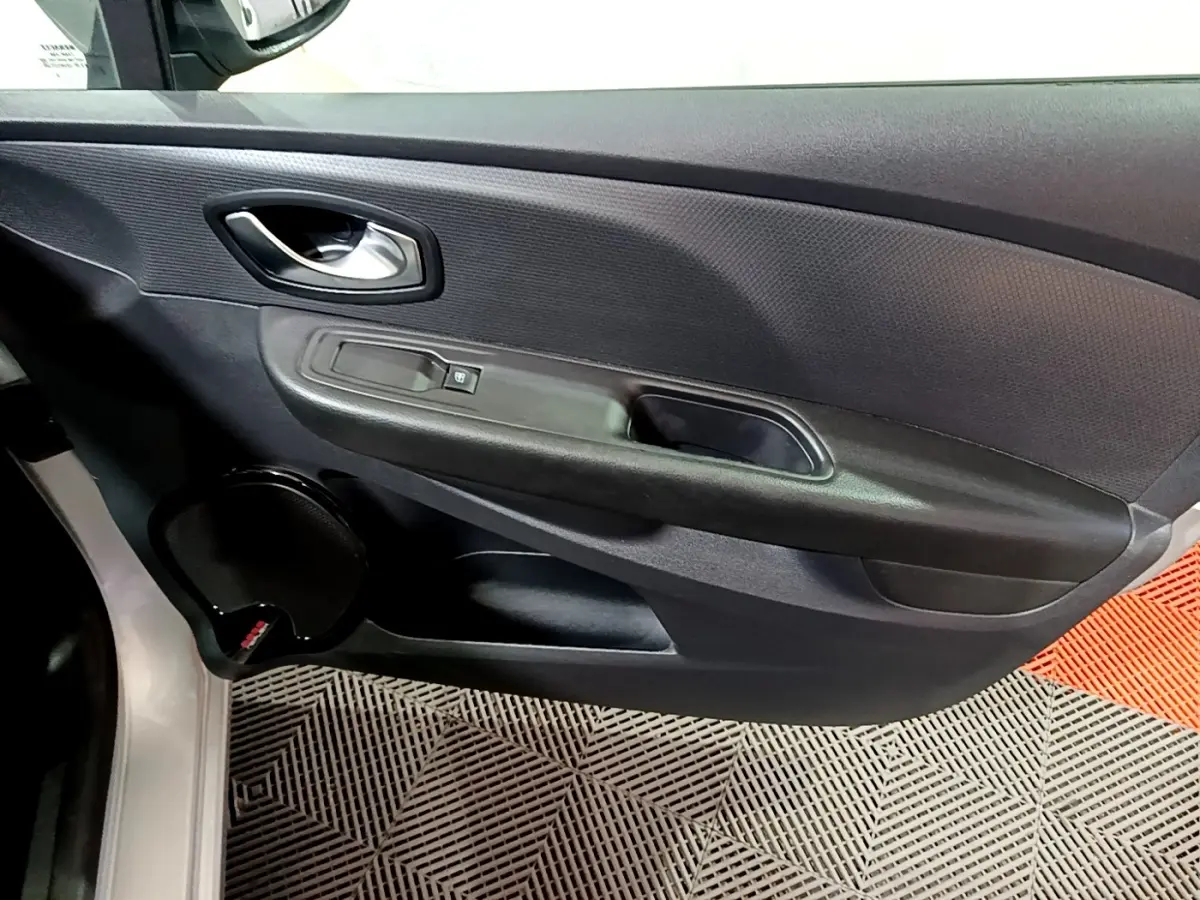 Vue rapprochée de la porte avant gauche gris clair d’une Renault Clio Business 2018 avec poignée et commande de vitre.