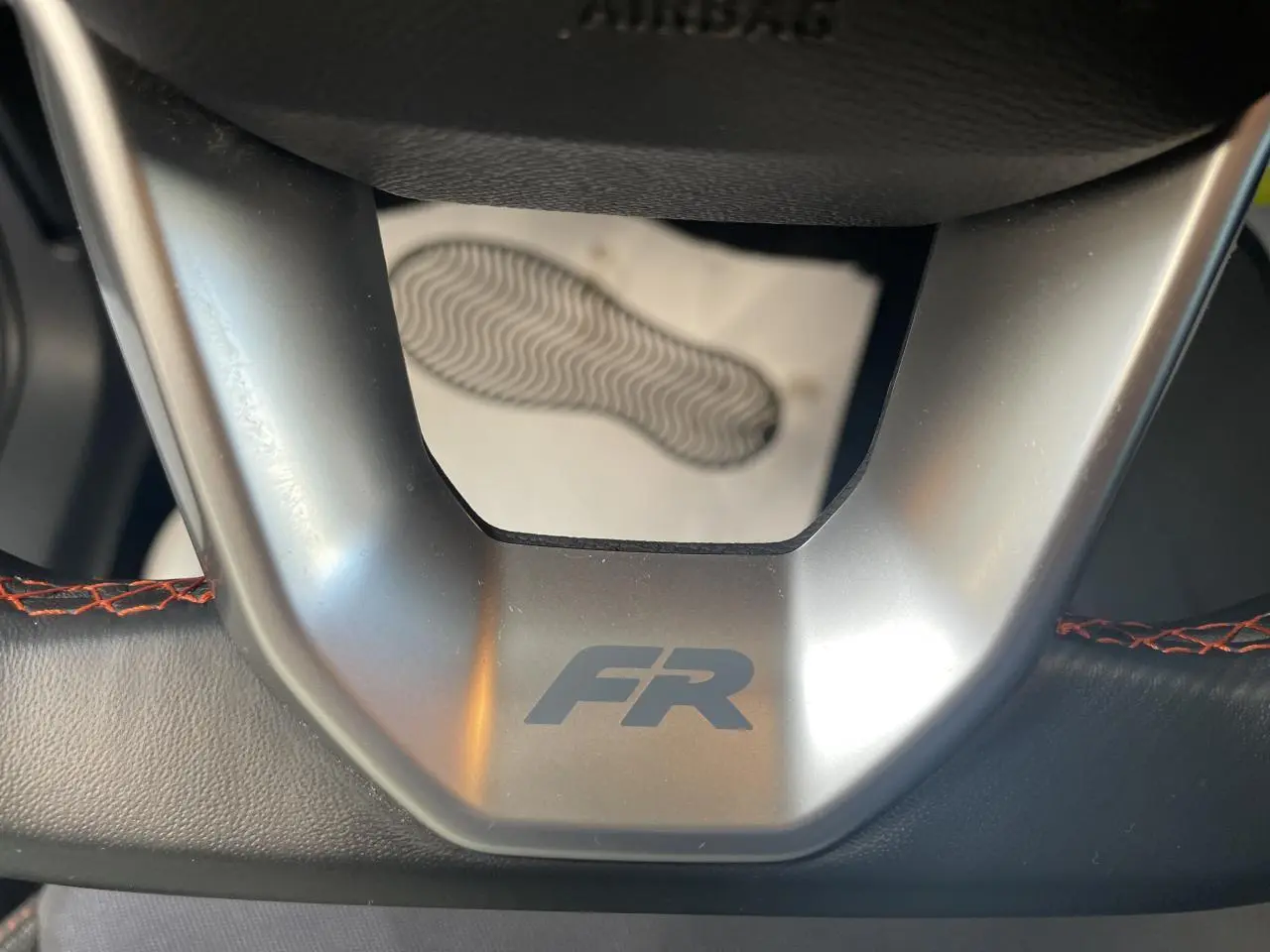 Gros plan sur le volant sport cuir noir avec logo FR gris et surpiqûres rouges du SEAT Arona 2024.