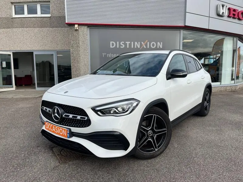 Mercedes GLA 200 AMG Line blanc polaire vu en 3/4 avant droit avec jantes AMG noires et calandre diamantée chrome.