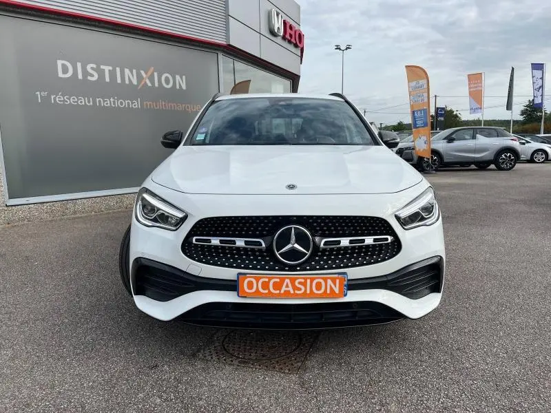 Mercedes GLA 200 AMG Line blanc polaire vu de face, calandre noire à motif diamant et plaque "OCCASION" orange visible.