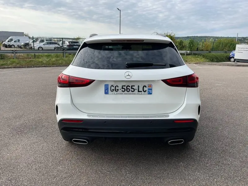 Vue arrière d'un Mercedes GLA 200 AMG Line blanc polaire avec feux LED et double sortie d'échappement chromée.