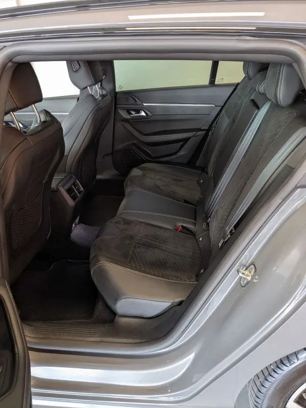 Vue intérieure arrière droite du Peugeot 508 SW gris selenium, montrant les sièges arrière en cuir noir et alcantara avec surpiqûres contrastées.