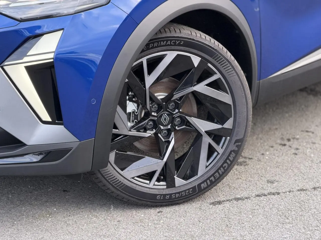 Gros plan sur la roue avant droite du Renault Captur Bleu Iron, jante aluminium 19 pouces Elixir au design géométrique.
